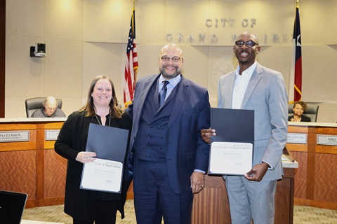 City Manager Bill Hills presents certificates to Rashad Jackson and Savannah Ware of the City of Grand Prairie planning department, inside Grand Prairie City Hall's council chambers