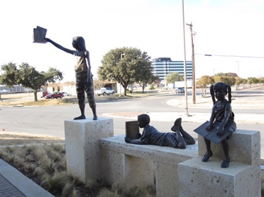 Journeys of the Mind - Children exploring the wonders of reading, cast in bronze and set on native Texas limestone greet residents as they arrive at the Grand Prairie Memorial Library, 901 Conover Drive. “Journeys of the Mind” is a three-statue grouping cast in 2009-2010.