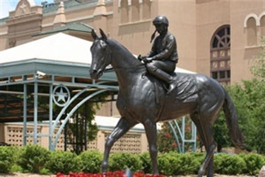 Lone Star Park Statue - Alysheba - This 1 ¼-scale bronze statue of Alysheba was unveiled at Lone Star Park on Sept. 29, 2004, the year that the Grand Prairie, Texas, racetrack hosted the Breeders’ Cup World Thoroughbred Championships. Since then, the 1000-pound statue, designed by renowned equine artist Lisa Perry, has been a focal point upon entering Lone Star Park’s main East Gate entrance.