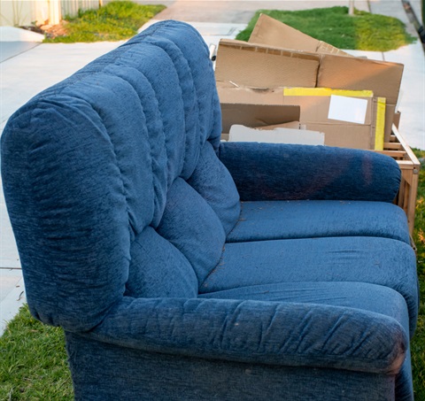 Blue sofa on the curb waiting for pickup