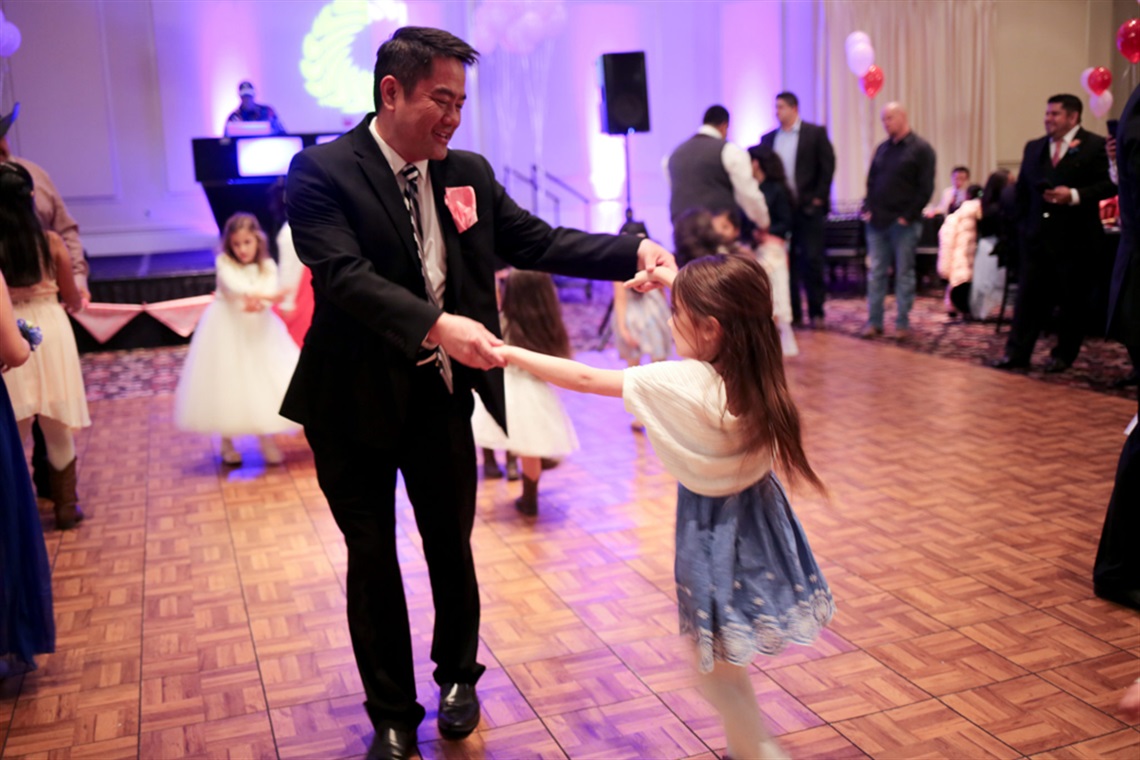 Dads and daughters dancing on dance floor