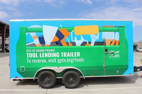 he side of a bright blue and green City of Grand Prairie Tool Lending Trailer.