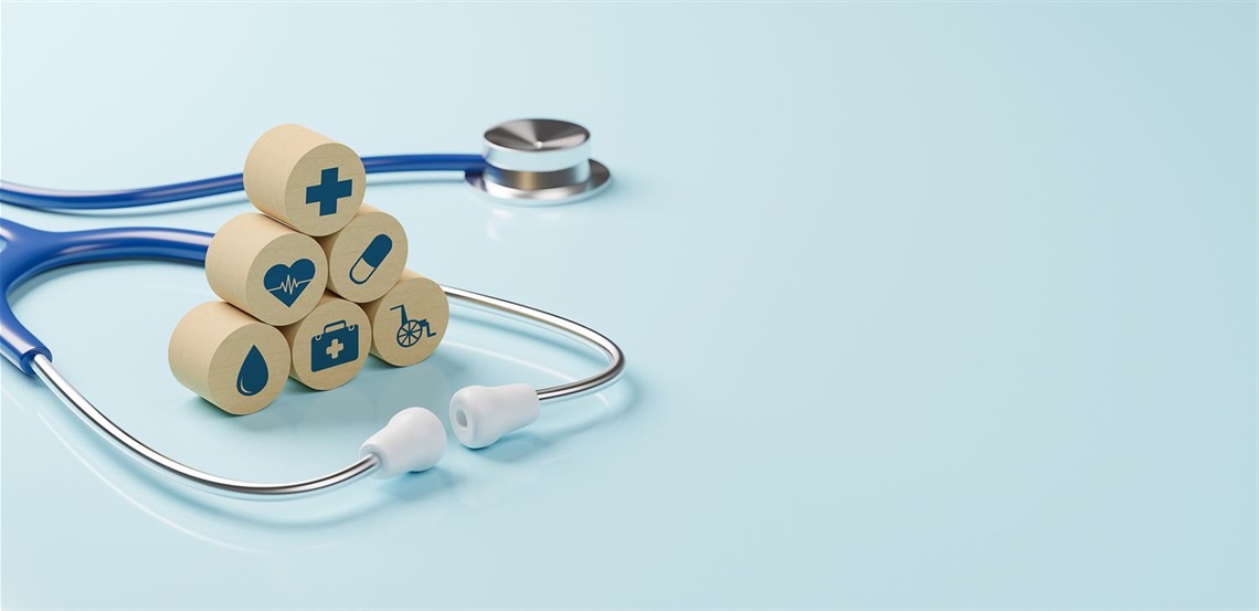 Stethoscope next to blocks with health-related icons on them