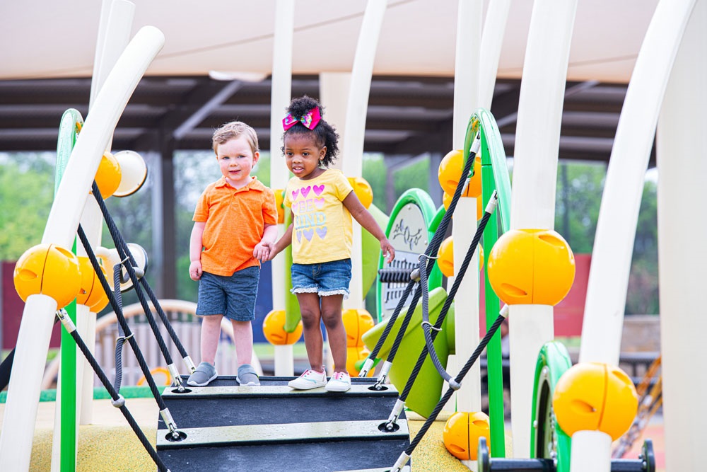 Two toddlers exploring colorful playground
