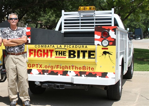 Truck used for mosquito spraying with Fight the Bite banner on tailgate